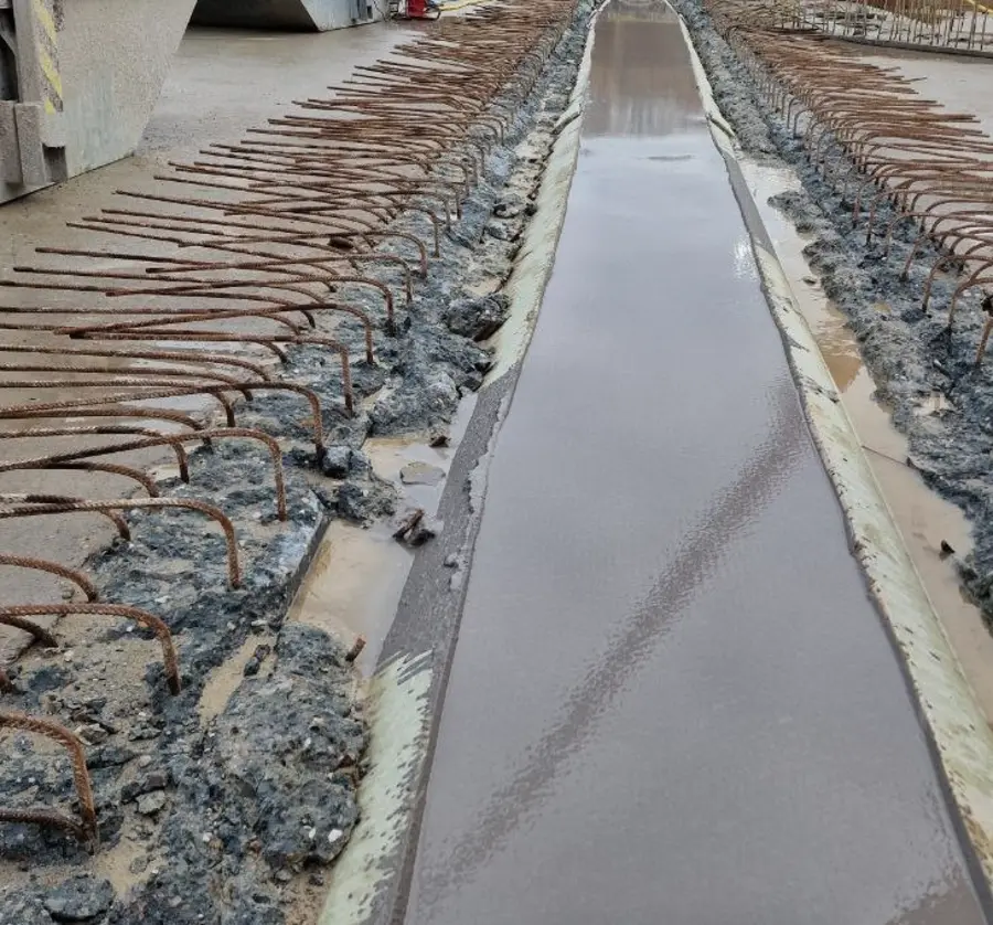 Poured grout strip between projecting reinforcement